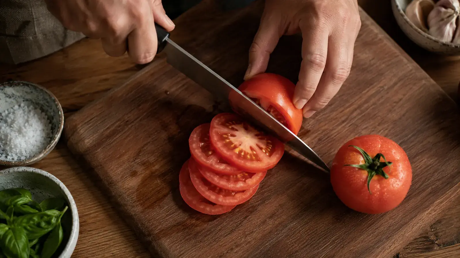 A restored chef's knife slicing cleanly through a tomato on a cutting board
