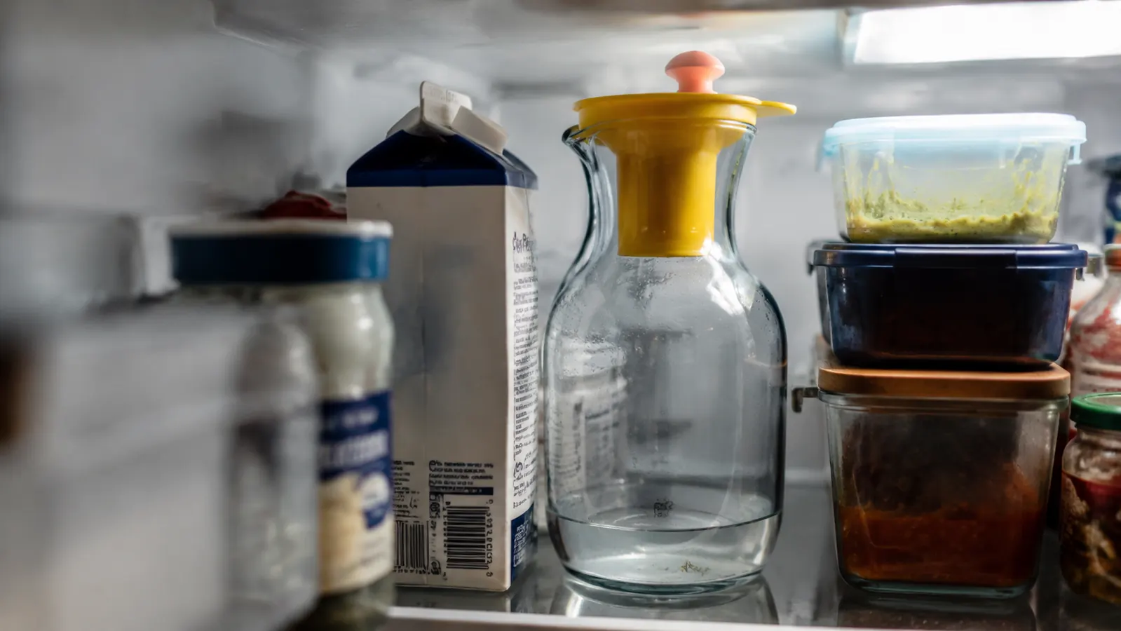Cluttered fridge shelf with the Primula carafe wedged between other containers